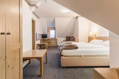 a hotel room with a bed and a desk at Hotel Krvavec in Cerklje na Gorenjskem
