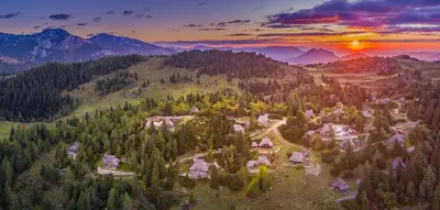 an aerial view of a village in the mountains at sunset at Chalet Encijan - Velika planina in Stahovica