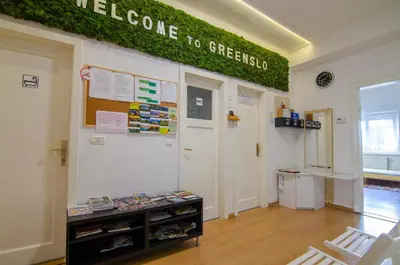 a classroom with a green sign on the wall at Family Guesthouse GreenSLO in Ljubljana