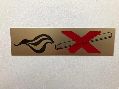 a sign on a wall with a cigarette and a symbol at Apartments GreenSLO in Ljubljana