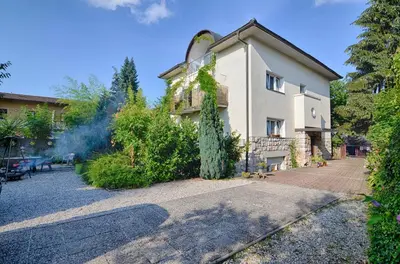 a house with a tree in front of it at Apartments GreenSLO in Ljubljana