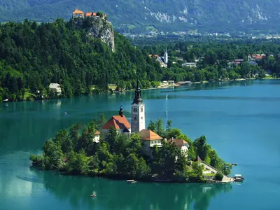 an island in the middle of a lake with a lighthouse at Apartments Julijana in Bled
