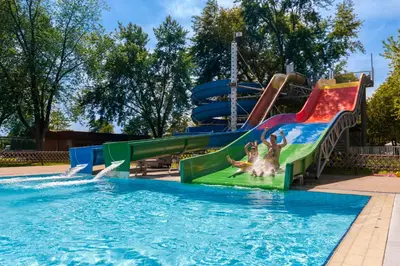 a pool with a water slide in a park at Hotel Ajda Depandance Prekmurska Vas - Terme 3000 - Sava Hotels & Resorts in Moravske Toplice