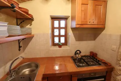 a kitchen with a stove and a sink and a window at Vineyard cottage Zidanca med vinogradi in Otočec
