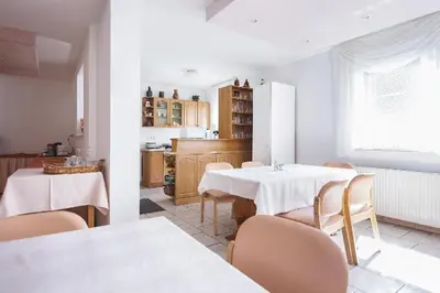 a kitchen with two tables and chairs in a room at Prenočišče Šinkec Nada in Moravske Toplice