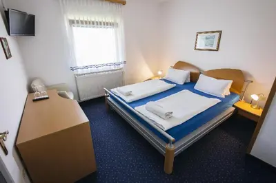a bedroom with a bed and a desk and a window at Prenočišče Šinkec Nada in Moravske Toplice