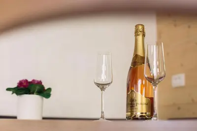 a bottle of champagne and two glasses on a table at Holiday house Jereka -Bohinj in Bohinj