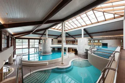 a large indoor pool in a building with windows at Hotel Ajda - Terme 3000 - Sava Hotels & Resorts in Moravske Toplice