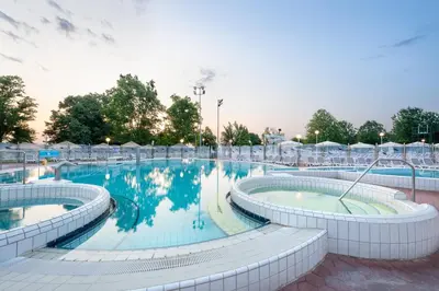 a large swimming pool with chairs around it at Terme Banovci - Hotel Zeleni Gaj in Banovci