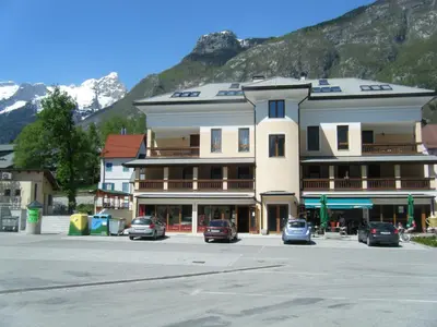 a large building with cars parked in a parking lot at Vila Bovec Sky mansard apartment in Bovec