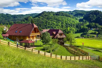 a house in the middle of a field with a fence at Farm Stay Pirc in Laško