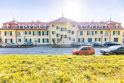 a large building with cars parked in a parking lot at Apartments Vila Golf - Flucher Turizem in Rogaška Slatina