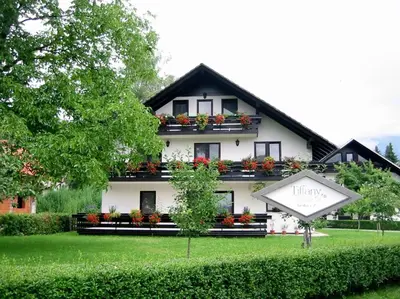 a large white house with a sign in front of it at Tiffany Pension Bled in Bled