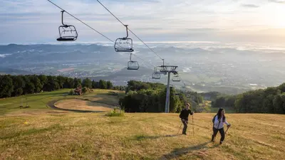 two people standing on a hill with a ski lift at Bolfenk lodge apartment in Pohorje