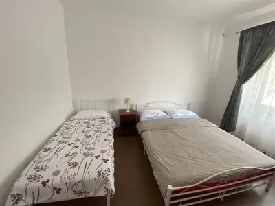 two beds in a small room with a window at Villa Acernis in Postojna