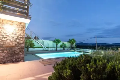 a swimming pool in front of a building at Apartment Trieste HerMes arT in Sežana