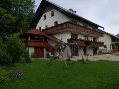 a large white house with a gambrel roof at Apartmaji Pika in Cerklje na Gorenjskem