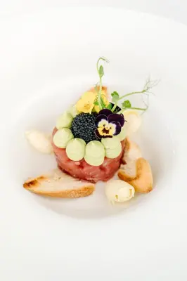 a plate of food with a doughnut with a flower on it at Hotel Grahor Depandance in Sežana