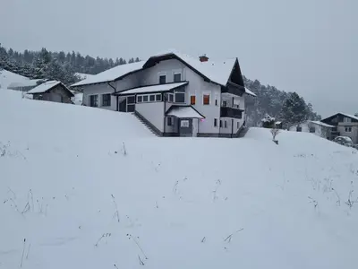 a house on a hill covered in snow at Apartma Juteršek in Libeliče