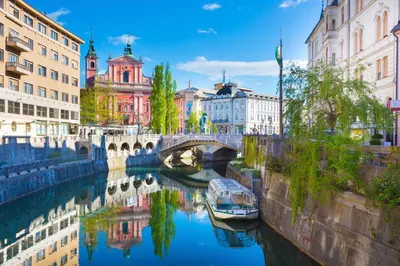 a river with a bridge and a boat in the water at Apartment Silver in Ljubljana