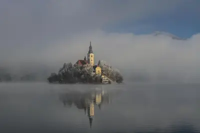 an island with a church in the middle of a lake at Apartment Mavrica Bled in Bled