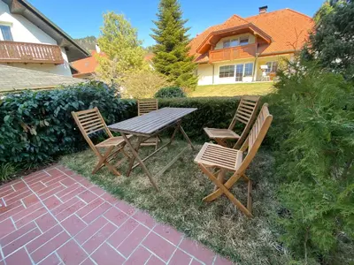 a picnic table and two chairs on a patio at House Eden with Mountain Views in Bled