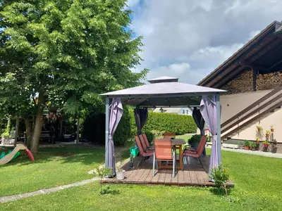 a gazebo with chairs and a table in a yard at Studio apartma Žirovnik in Cerklje na Gorenjskem