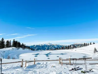 a view of a snow covered slope with skis and a fence at Sunshine Apartments Golte COMFORT in Mozirje