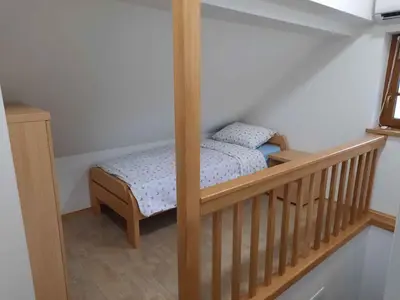 a small bed in a room with a wooden crib at Holiday home in Semic Kranjska Krain 42896 in Semič
