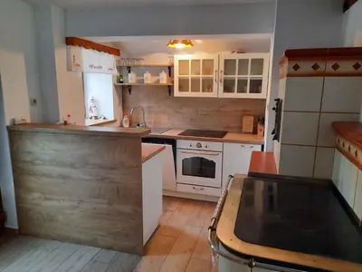 a kitchen with white cabinets and a wooden floor at Holiday home in Semic Kranjska Krain 42896 in Semič