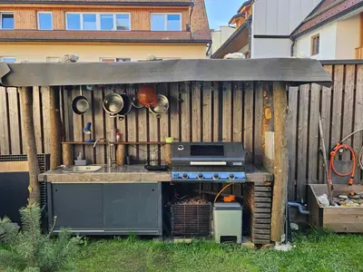 an outdoor kitchen with a stove in a backyard at Apartment Slovan in Škofja Loka