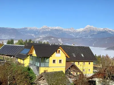 a yellow house with solar panels on top of it at SPA Tubej - Adults Only in Bohinj
