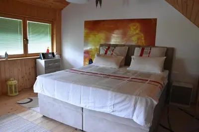 a bedroom with a large white bed with a painting on the wall at Apartma Silvia in Metlika