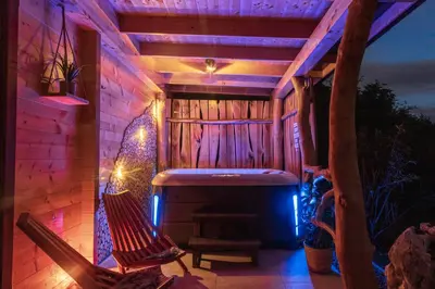 a patio with a bench and a hot tub at Lake Cottage - Koča ob jezeru in Nazarje