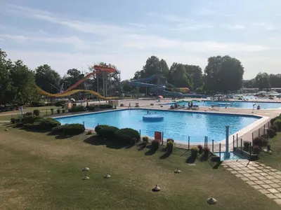 a large swimming pool in a park with a roller coaster at Spa House Lotus in Terme Čatež in Čatež ob Savi