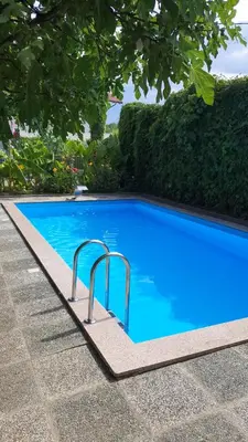 a blue swimming pool with two metal rails in a yard at APARTMAN MURKO P-3 in Brest