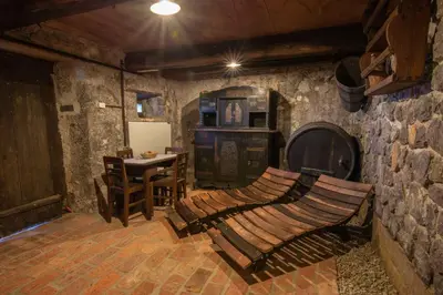 a room with a stone wall with a wooden bench at Holiday home in Otocec - Kranjska Krain 26039 in Otočec