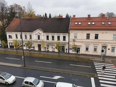 a city street with cars parked in front of buildings at Apartment for four with free parking in Ljubljana
