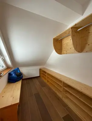 an attic room with wooden cabinets and wooden floors at Apartma LD Puščava in Lovrenc na Pohorju