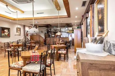 a restaurant with tables and chairs and a bar at Terme Banovci - Hotelsko naselje Zeleni gaj in Banovci