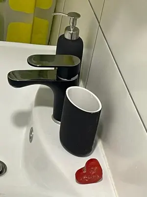 a bathroom sink with a cup and a faucet at Brasilia apartment in Ljubljana