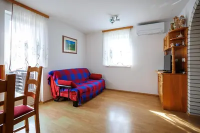a living room with a blue couch and a tv at Vineyard cottage Cvitkovič in Adlešiči